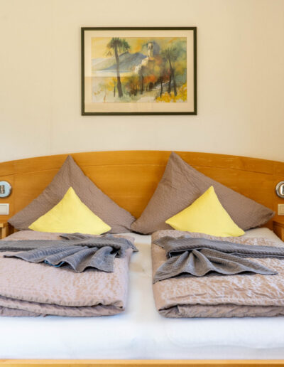 Doppelzimmer Bett Frontalansicht mit Bilderrahmen und Nachtkästchen