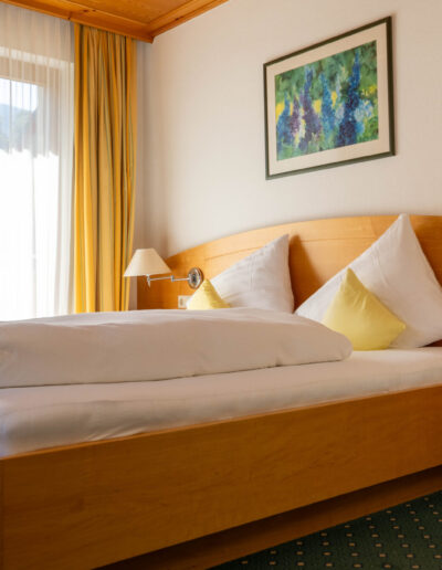 Familienzimmer Bett seitliche Ansicht mit Bilderrahmen und Nachtkästchen