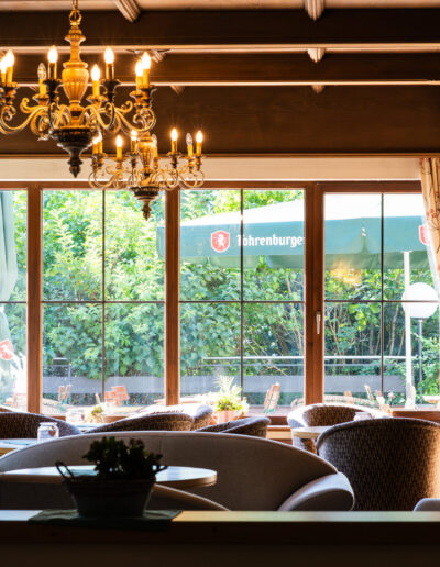 Lounge Cresta Garni mit Tischen, Stühlen und Lampen sowie Aussicht auf die Terrasse
