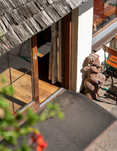 Blick auf Eingang zur Terrasse von oben mit Stühlen, Tischen